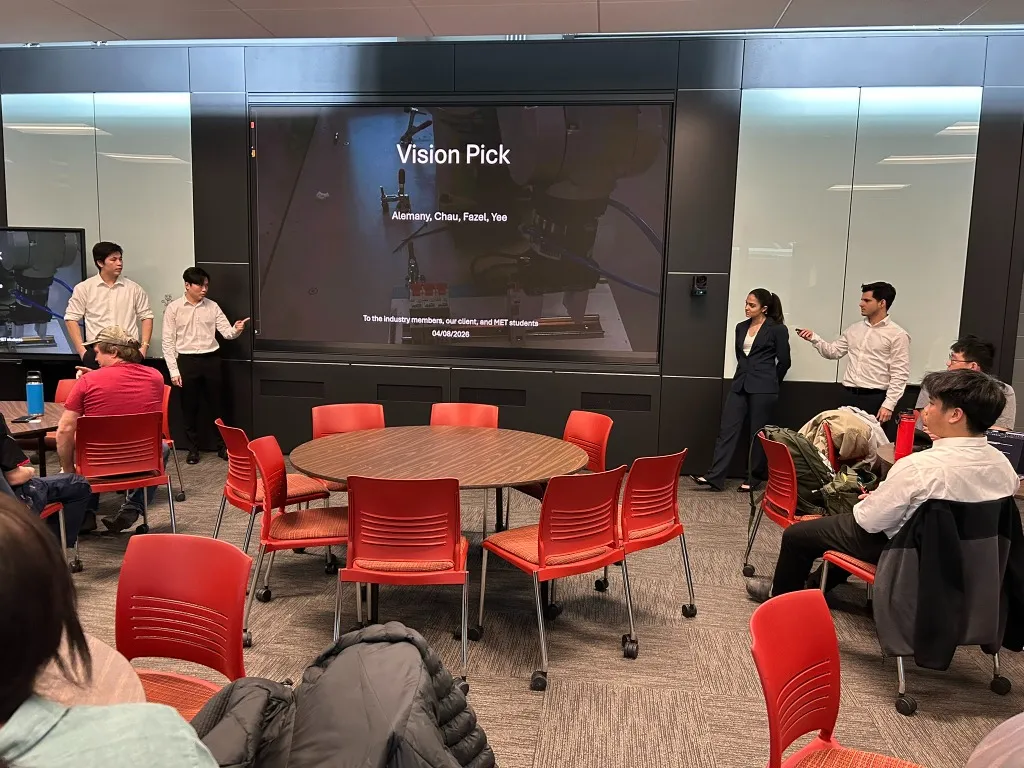 Capstone presentation photo showing the team presenting the VisionPick workcell to an audience in a classroom setting.